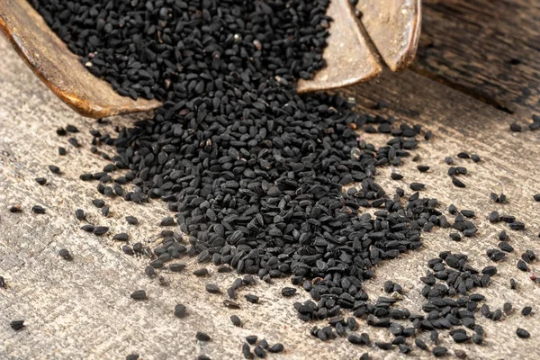 Черные семена тмина на столе, крупным планом — стоковое фото