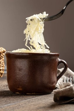 Bir çömlekten çatalla mayalanmış lahana kaldırmak.