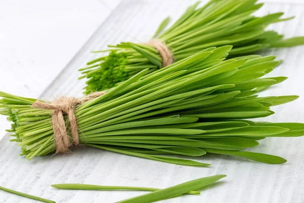 Frisches Gerstengras auf einem weißen Tisch — Stockfoto