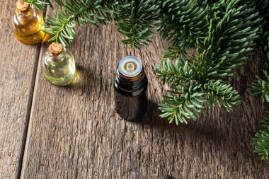 Fotokopi alanı olan, taze köknar dallarıyla dolu bir yağ şişesi.