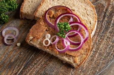 Domuz yağlı ekmek, kıtır kıtır, soğan halkalarıyla süslenmiş.