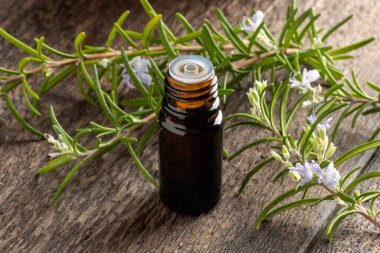 Taze biberiyeli koyu bir yağ şişesi.