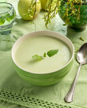 Masadaki yeşil bezelyelerden yapılmış kremalı çorba.