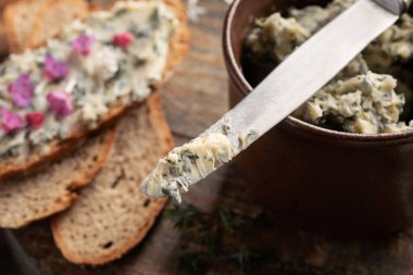 Arka planda ekmek ve bıçaktaki ısırgan otlarından yapılan bitkisel tereyağı.