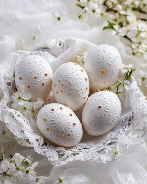 Beyaz Paskalya yumurtaları balmumuyla süslenmiş, delinmiş deliklerle süslenmiş.