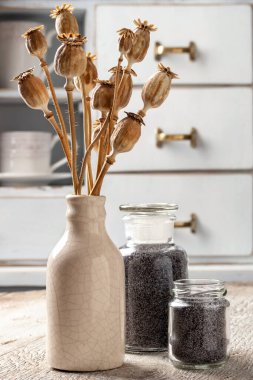 Beyaz bir masada kurumuş kapsüllü haşhaş tohumları