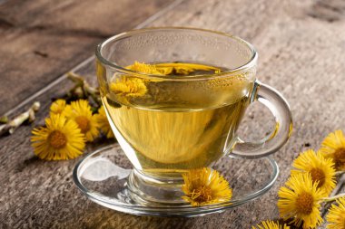 Bir fincan çay ve taze bitki.