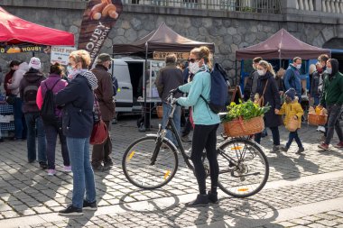 PRAGUE, CZECH REPUBLIC - 25 Nisan 2020: Koronavirüs salgını nedeniyle Naplavka çiftçi pazarında insanlar koruyucu maskeler takarak ve mesafeyi koruyarak alışveriş yapıyorlar