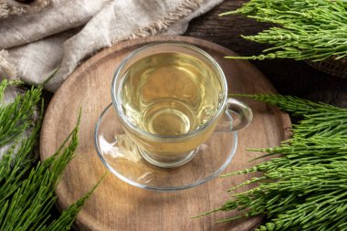 Taze at kuyruğu dallı bir fincan bitki çayı.