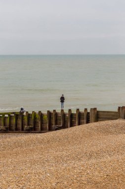 Genç delikanlı denize bakan bir groyne Dengeleme