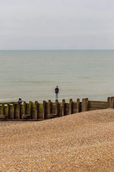 Genç delikanlı denize bakan bir groyne Dengeleme