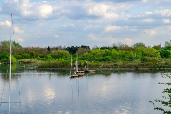 Four sailing boats moored on calm lake. — Stock Photo, Image