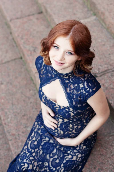 Hermosa joven pelo rojo mujer embarazada sentada en las escaleras — Foto de Stock