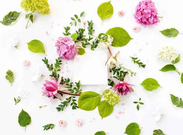 Maqueta de tela blanca con flores, hojas y pétalos florecientes —  Fotos de Stock