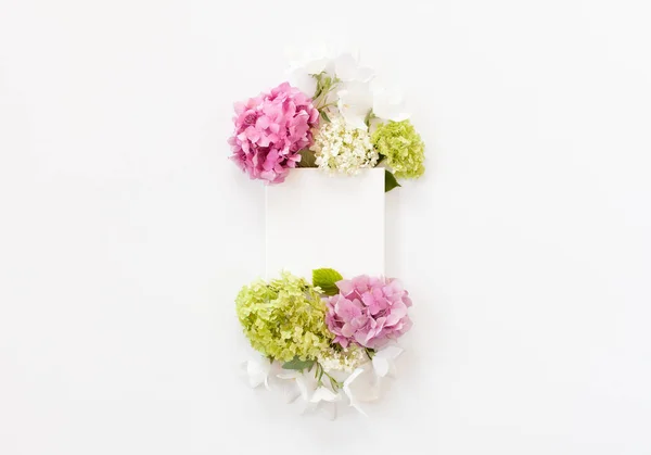 Weiße Stoffattrappe mit blühenden Blumen und Blättern. flache Lage — Stockfoto