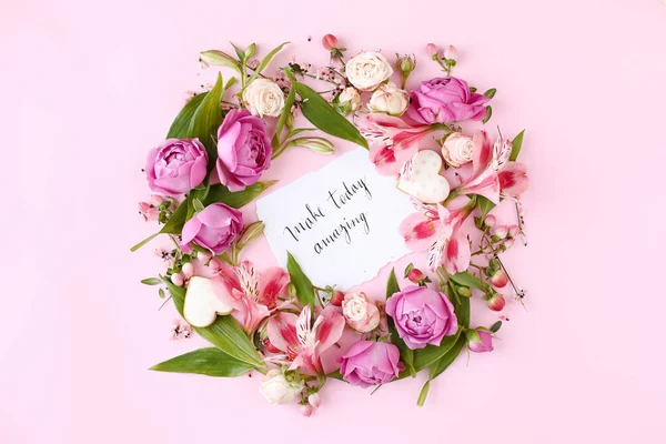 花のフレームでピンクの背景にカード「今日を素晴らしいものにする」. ストックフォト