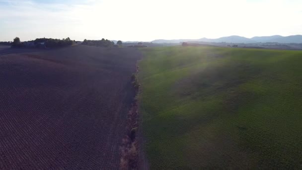 Aerial shot, gorgeous tucany hills landscape with sun flare, flying above the fields, tuscany flyover — Stock Video