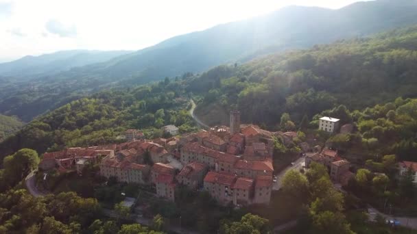 Plano aéreo, magnífico clásico pequeño pueblo italiano en el paso elevado de la colina, en medio de la naturaleza verde — Vídeo de stock