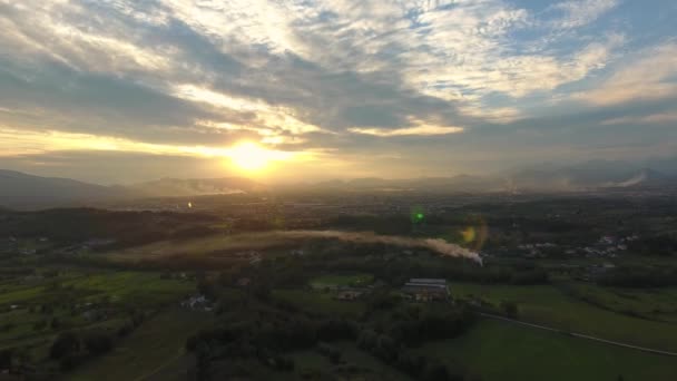 Plano aéreo, hermoso paisaje al atardecer, humo en el medio, en el medio de la llanura, hecho con dron — Vídeo de stock