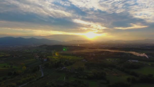 Снимок с воздуха, великолепный пейзаж на закате, дым посередине, посреди равнины, сделанный с беспилотником — стоковое видео