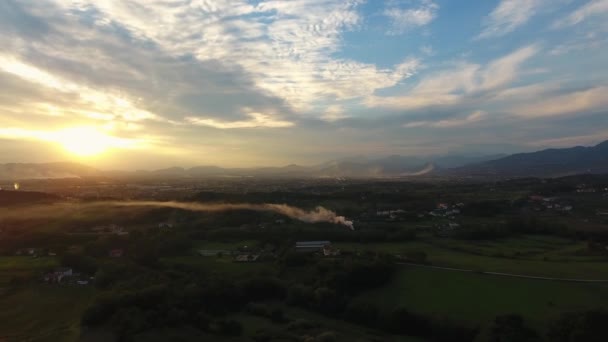 Κεραία βολή, πανέμορφο τοπίο με ηλιοβασίλεμα, καπνό στη μέση, στη μέση του κάμπου, που έκανε με drone — Αρχείο Βίντεο