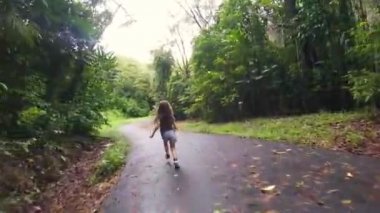 Yolun ortasında yeşil doğa üzerinde çalışan küçük bir kız