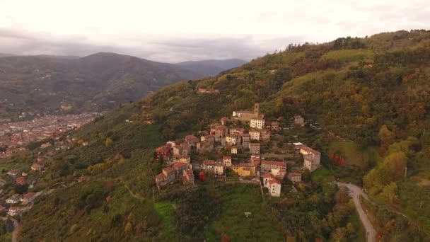 Снимок с воздуха, великолепная маленькая деревня на холме, посреди осенних красок — стоковое видео