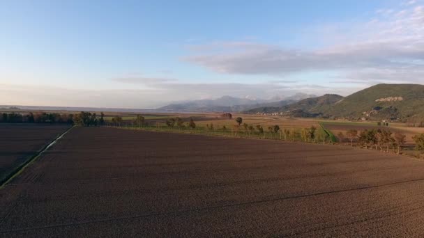 Disparo aéreo, caída de paisaje, volando sobre campos y un pequeño río — Vídeos de Stock