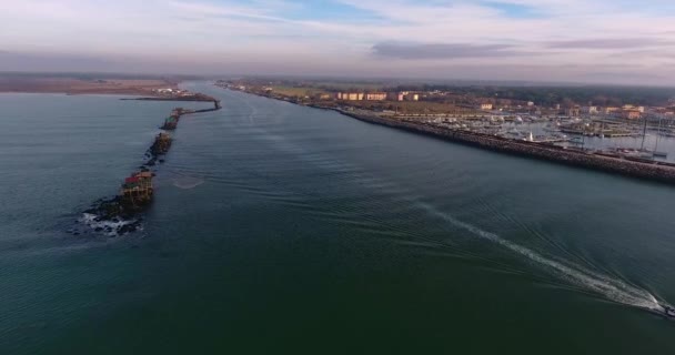 Alcune case di pescatori, una costa e una barca che va veloce, in Toscana, Italia, filmato con drone — Video Stock