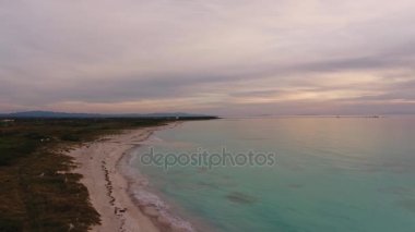 Havadan çekim, harika beyaz kumsalda güzel bulutlar ve drone ile filme çok sakin deniz günbatımı