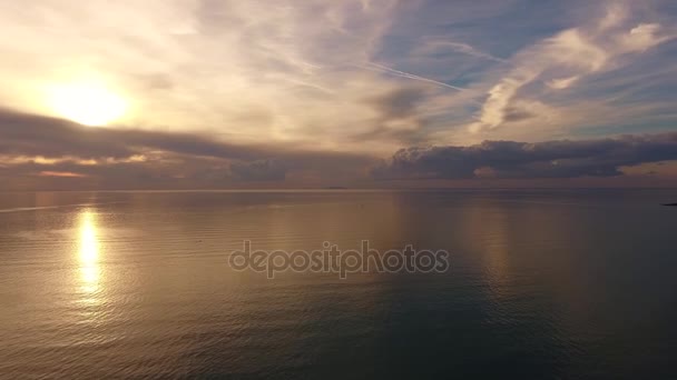 ドローンと撮影された空中ショット、雲がたくさんある夕日の光の中で信じられないほど美しい穏やかな海 — ストック動画