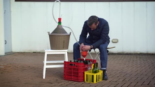Homme barbu remplissant des bouteilles de vin de vin blanc, objectif sélectif — Video