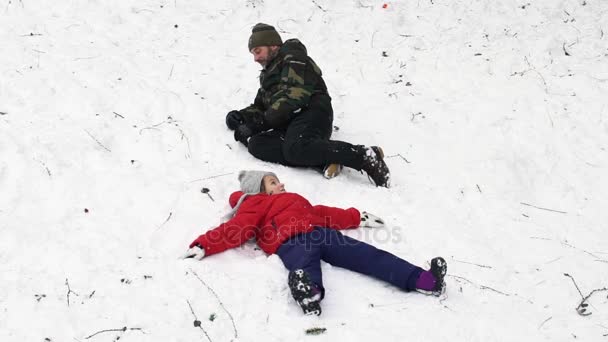 Slow motion video of father and daughter playing together on the snow, HD — Stock Video