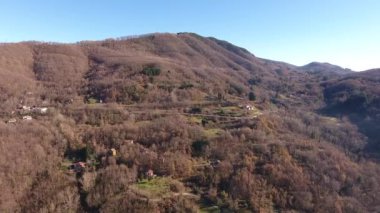 Hava atış, ahşap turuncu kuru ile dağlarda bırakır, gökyüzünde, yüksek güneş sonbahar ortasında küçük köy dron, 4 k ile filme