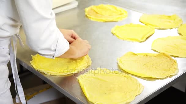 Una cocinera en la cocina del restaurante de catering poniendo algunos panqueques o crepes antes de rellenar con el relleno, 4K — Vídeo de stock