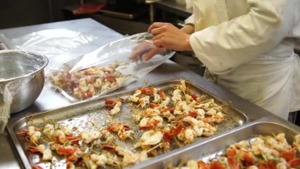 Una cocinera poniendo un poco de pincho de camarón en las bolsas de plástico antes de ponerlos bajo vacío para la restauración, 4K — Vídeos de Stock