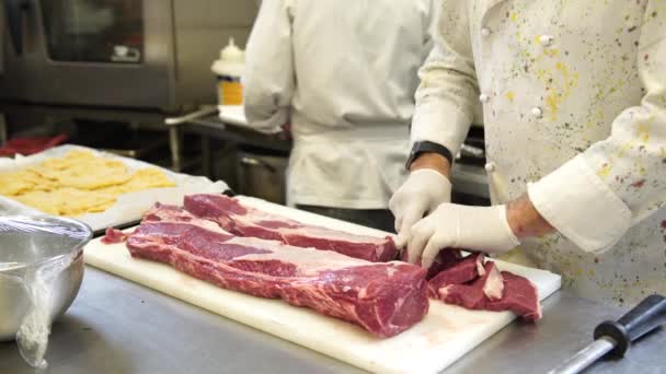 Een chef-kok het vlees voor de steaks in zijn keuken in Italië, 4k snijwerk — Stockvideo