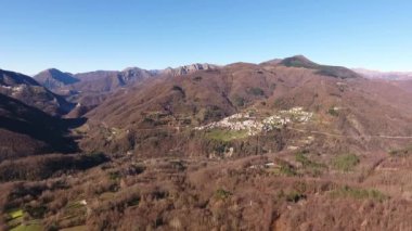 Hava atış, ahşap turuncu kuru ile dağlarda bırakır, gökyüzünde, yüksek güneş sonbahar ortasında küçük köy dron, 4 k ile filme