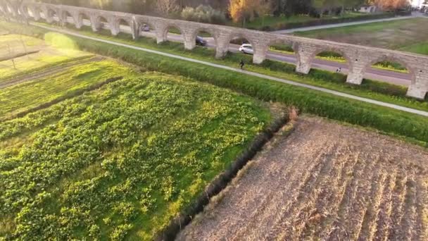 Tiro aéreo, campos nebulosos, um antigo aqueduto romano na Itália e carros dirigindo atrás dele, filmado com drone, 4K — Vídeo de Stock