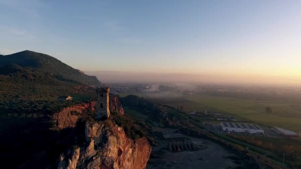 Снимок с воздуха, башня Упеццинги на скалистом обнажении в Италии, Тоскана, на закате, снятый дроном — стоковое видео