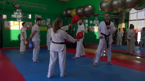 Sesión de entrenamiento de taekwondo para adultos en el gimnasio, entrenador explicando una nueva patada, 4K — Vídeo de stock