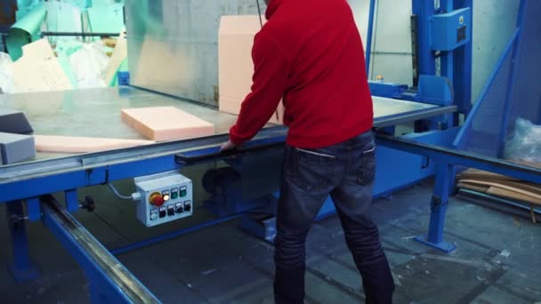 Um homem cortando borracha de espuma na máquina de corte enorme, 4K — Vídeo de Stock