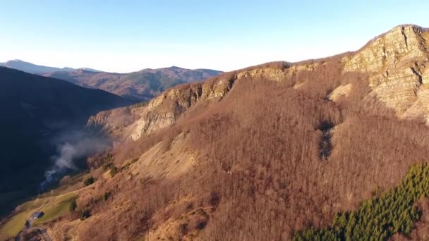 Aerial shot, autumn landscape in the high mountains with coniferous wood, sun going down, filmed with drone — Stock Video