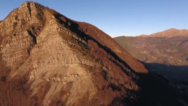 Aerial shot, autumn landscape in the high mountains with coniferous wood, sun going down, filmed with drone — Stock Video