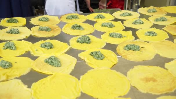 Eine Köchin in der Küche des Catering-Restaurants, die ihre Pfannkuchen mit Ricotta und Spinat füllt, 4k — Stockvideo