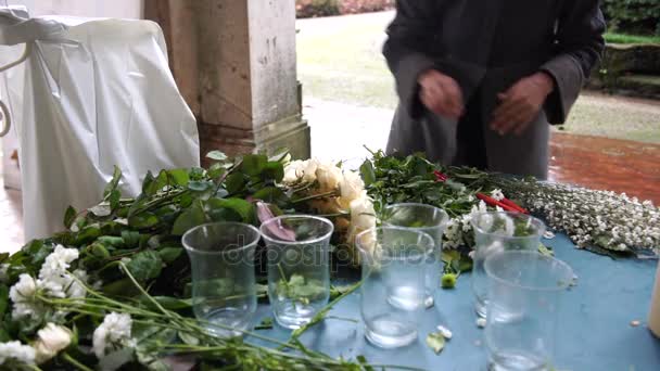 En florist som förbereder blommor för bröllop på en regnig dag i Italien, 4k — Stockvideo