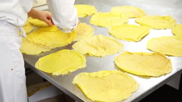 Una cocinera en la cocina del restaurante de catering poniendo algunos panqueques o crepes antes de rellenar con el relleno, 4K — Vídeo de stock