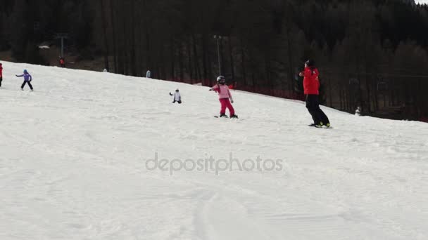 La Villa, Italia, 15 de marzo de 2017 - Vídeo editorial de una niña tomando su primera clase de snowboard en las montañas de los Alpes en Sud Tirol, Italia, 4K — Vídeos de Stock