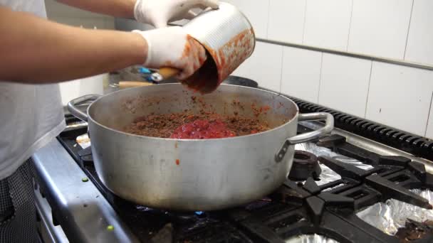 Un cocinero masculino añadiendo tomates en la salsa de carne, 4K — Vídeo de stock