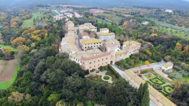 Aerial shot, una pequeña ciudad antigua situada en medio del paisaje rural con campo cultivado y una gran cantidad de olivos en Toscana, Italia, tiro con dron — Vídeos de Stock